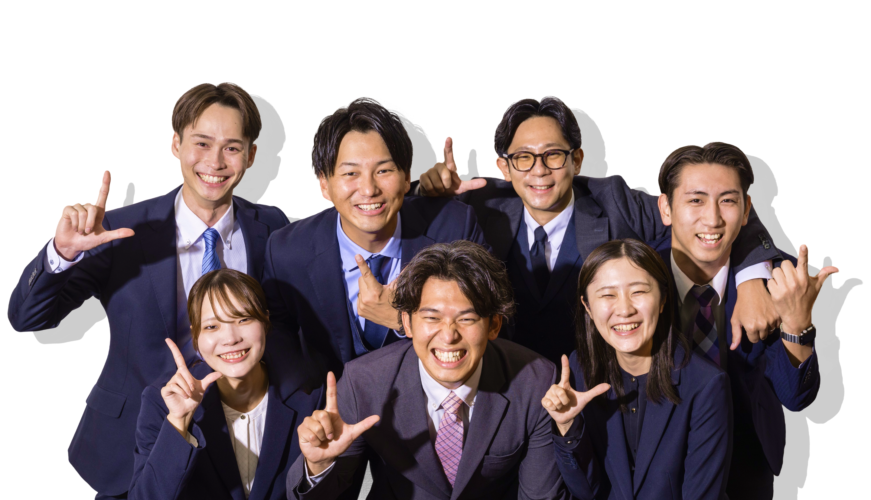 スーツ姿の男女8名が笑顔でポーズを取り、活気ある雰囲気の集合写真
